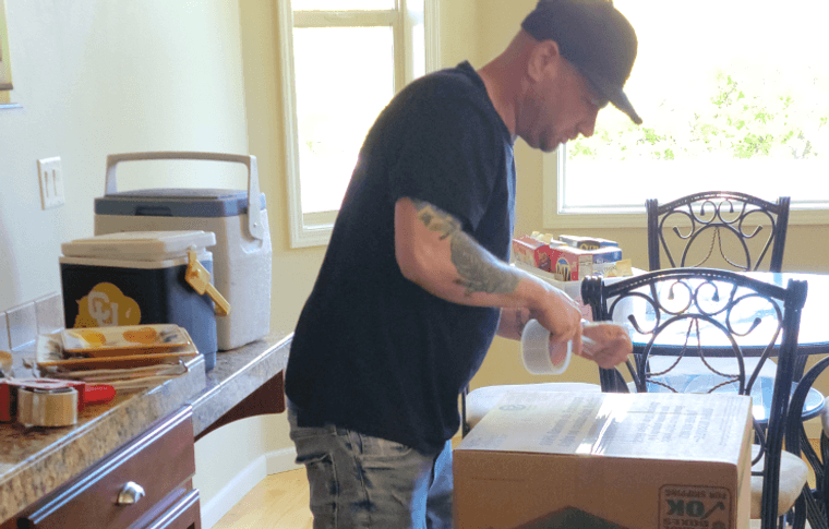 Mover wrapping dishes in packing paper